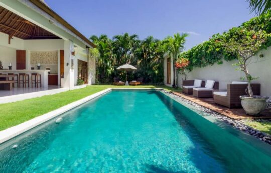 Swimming pool during sunny seminyak day with villa exteriors