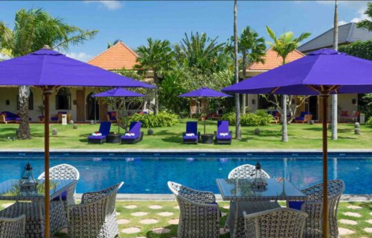 Swimming pool with day beds and sunbrellas on a sunny day