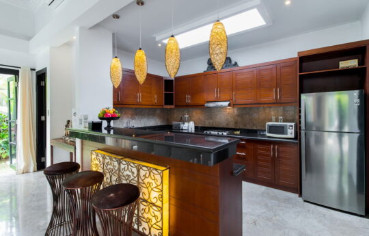 Modern kitchen at villa with three bar stools at island bench