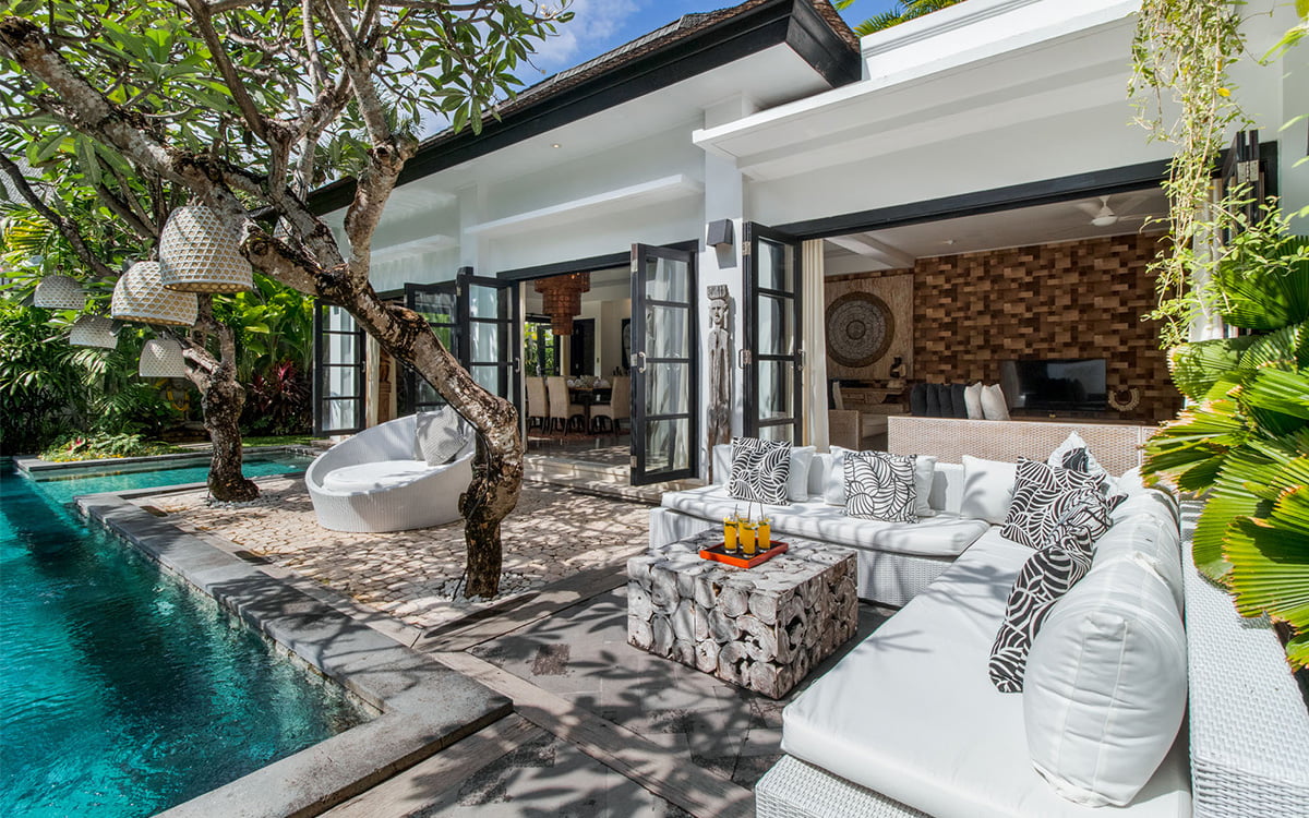 L shaped outdoor sofa with swimming pool and villa exterior views