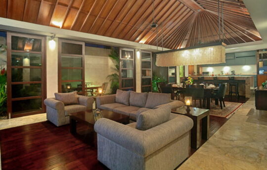 Lounge area of villa with sofas and kitchen