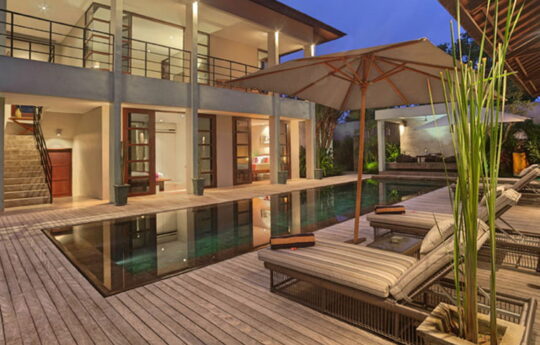 Pool at night with deck area and day beds