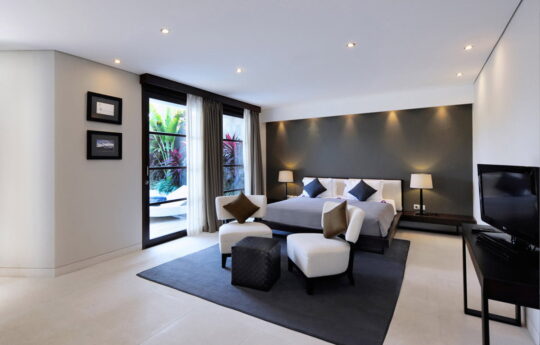 Modern bedroom with king bed and external view to swimming pool
