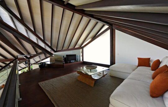 living area of villa in bali with tv and coffee table and l shaped white couch