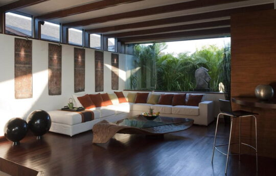 Lounge room of villa with white L-shaped lounge