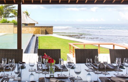 Dining by the pool & ocean with grassy garden views