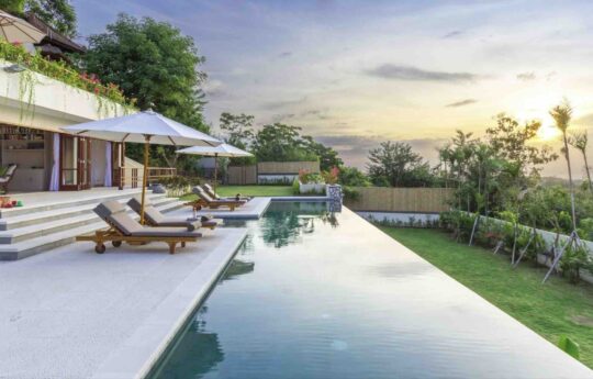 swimming pool at sunset with day beds