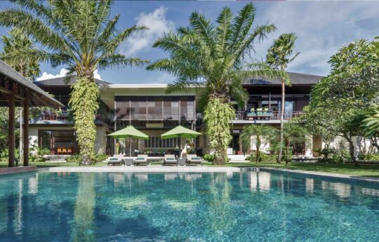 villa exteriors with palm trees and swimming pool with sunbrellas