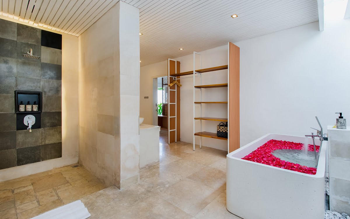 Modern ensuite bathroom with bath full of rose petals