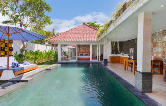 Swimming pool views on sunny day with villa exteriors in background