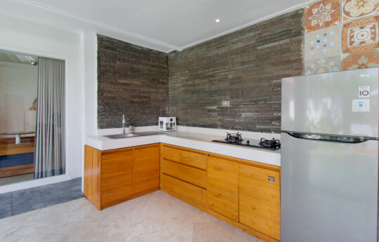 Kitchen area of villa with fridge and cooktop