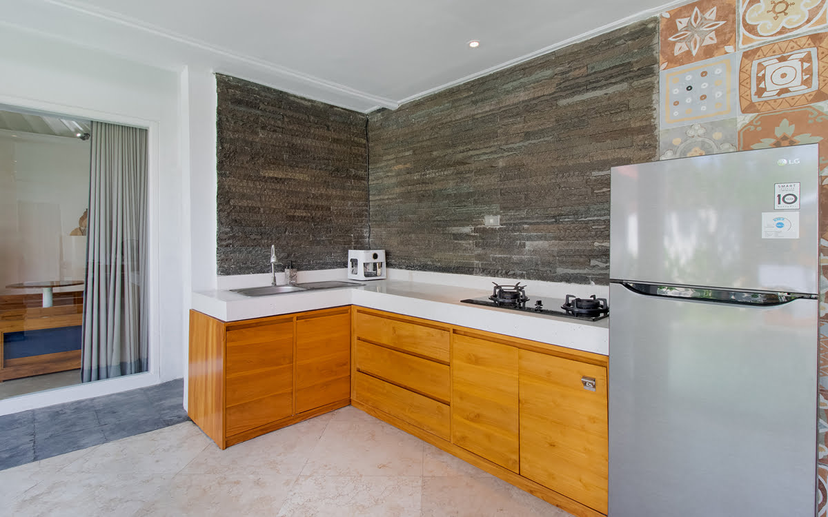 Kitchen area of villa with fridge and cooktop