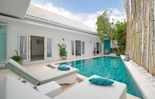 Villa Brightside Pool area with two daybeds and view to bedrooms at Villa Brightside in Canggu