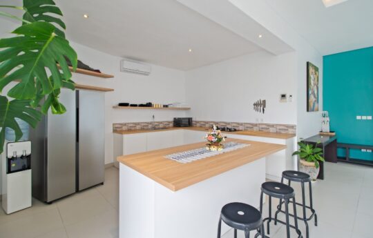 Modern kitchen of villa with breakfast bar and three stools