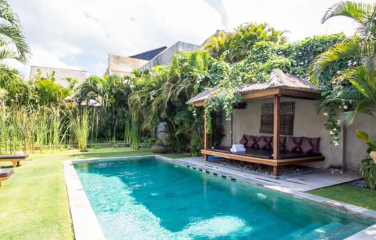 Cabana by the poolside of villa on sunny day with lush tropical garden views