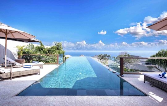 Swimming pool during day with ocean views in background