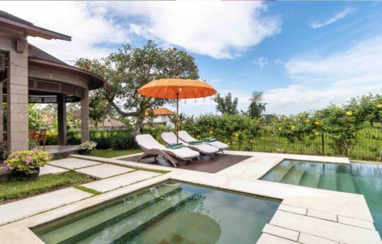 Swimming pool and deck area of villa with rice field views