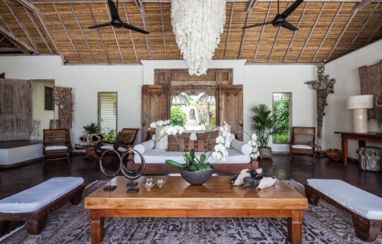 Modern lounge area of bali style villa with sofas and coffee table