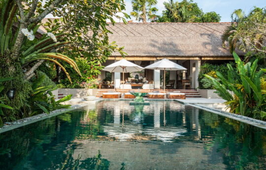 Swimming pool and villa exterior on sunny day