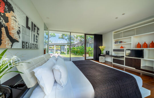 Modern bedroom oif villa with king bed and view of garden