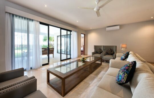Lounge room area of villa with sofa and coffee table