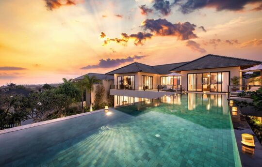 Villa Dewi Lanjar swimming pool and villa exterior at dusk with lights on
