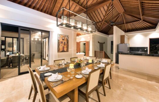 Dining table with seating for 8 people and kitchen in background