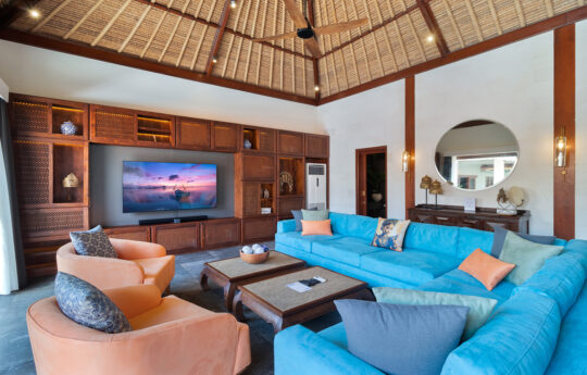 Large blue comfy couch of villa in living room with large TV