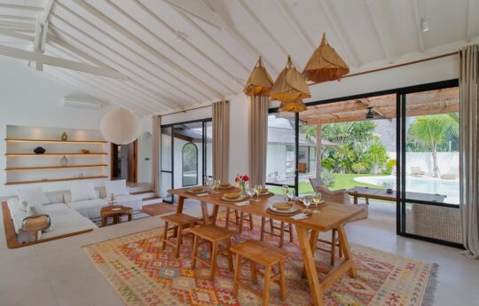 Dining table with seat for 8 people and living area with sunken lounge and TV