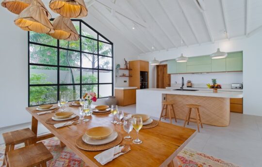 Modern kitchen area with dining table with cutlery and plates