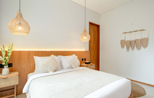 Modern bedroom with kin sized bed and two hanging tropical lights