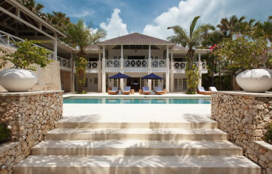 View of villa & swimming pool on sunny day