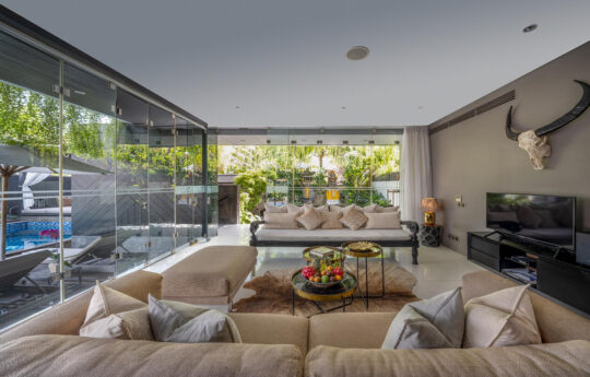 Large open plan living areas with pool views through glass doors