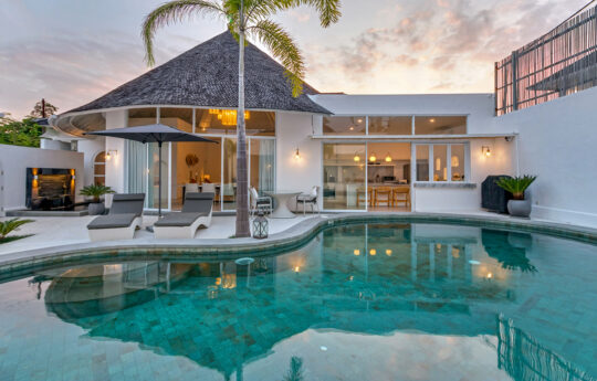 Villa at sunset with views of pool and exterior living areas and bedrooms